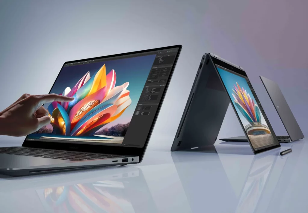 "Une vue latérale de deux ordinateurs portables modernes sur une surface blanche et réfléchissante. L'ordinateur portable au premier plan est un modèle convertible ou tactile, dont un doigt touche l'écran.
