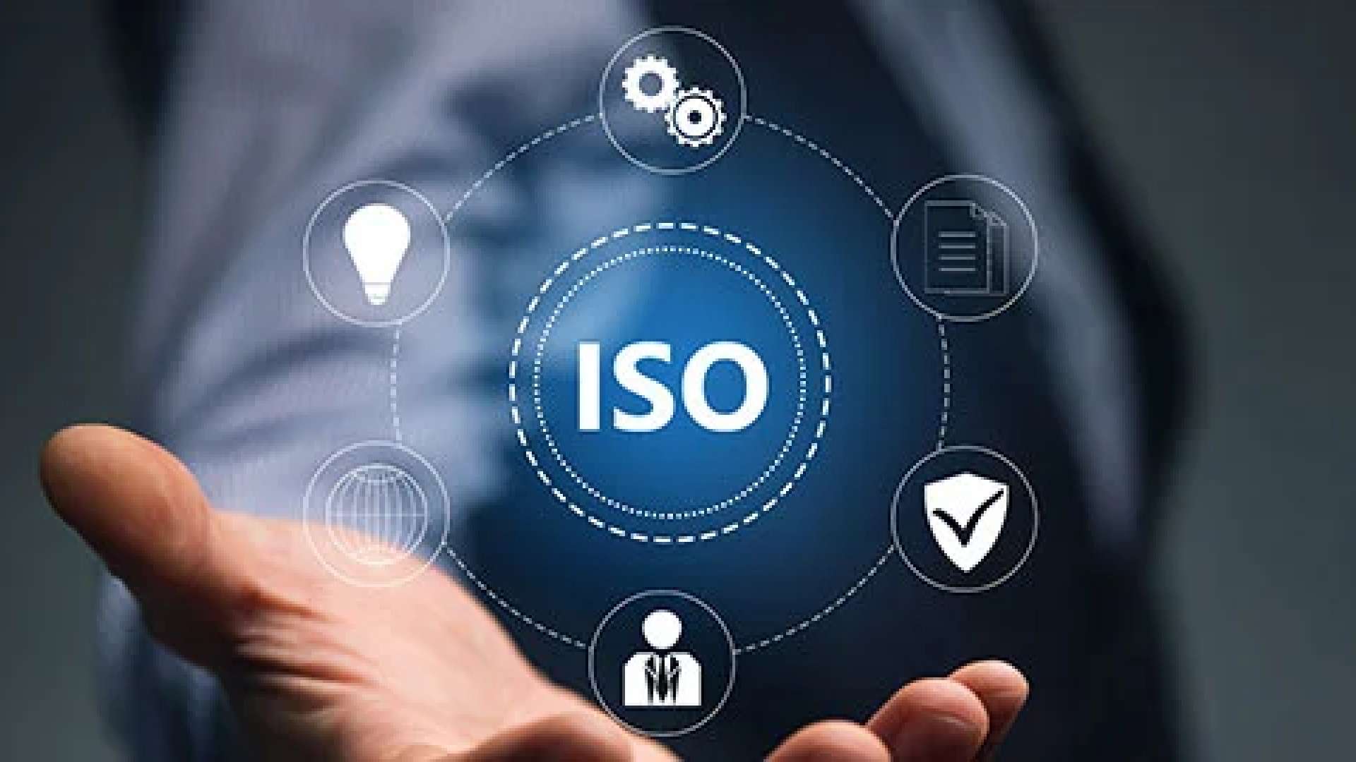 Illustration d'une main ouverte soutenant le sigle ISO, entouré d'icônes symbolisant la gestion, la qualité, la sécurité et l'innovation.
