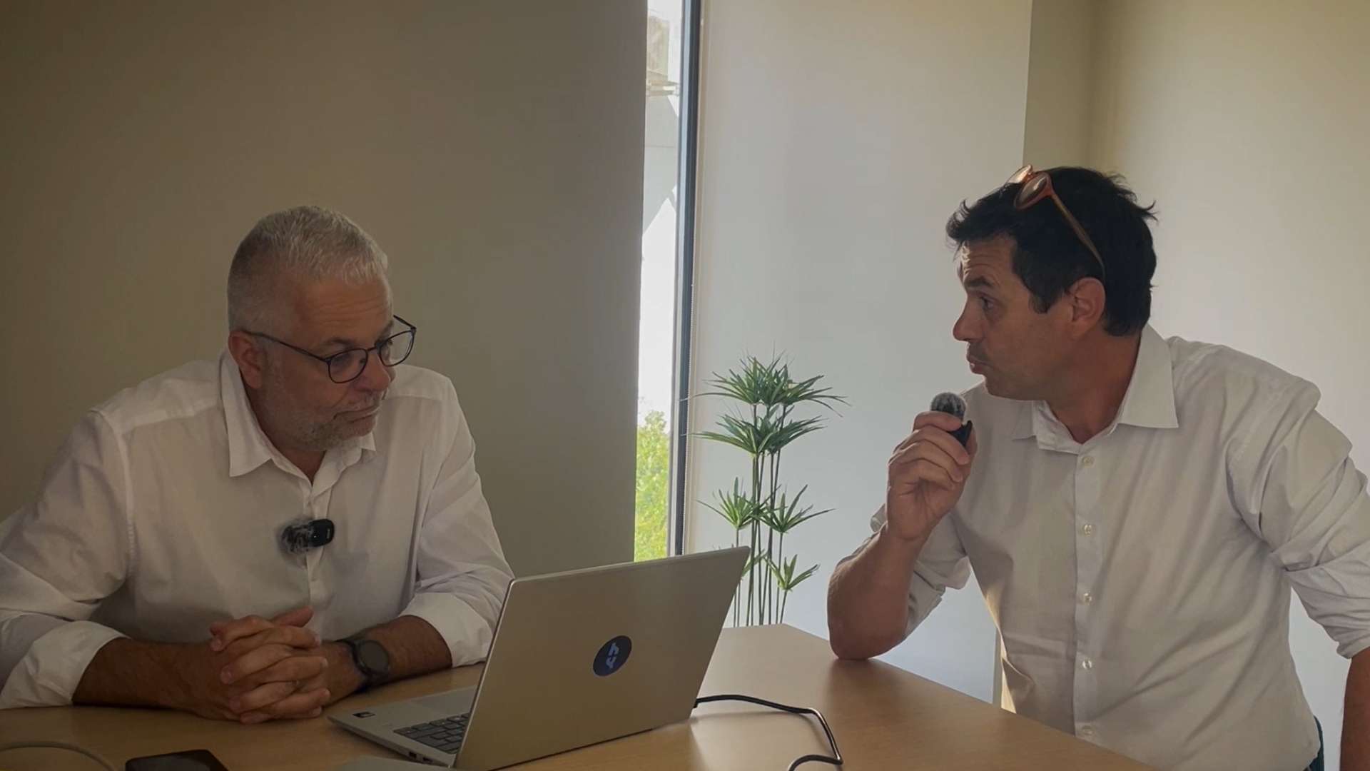 Deux professionnels représentant Heliaq discutent sur un sujet informatique.