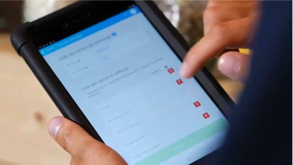 Personne utilisant une tablette tactile pour consulter ou renseigner un formulaire numérique.