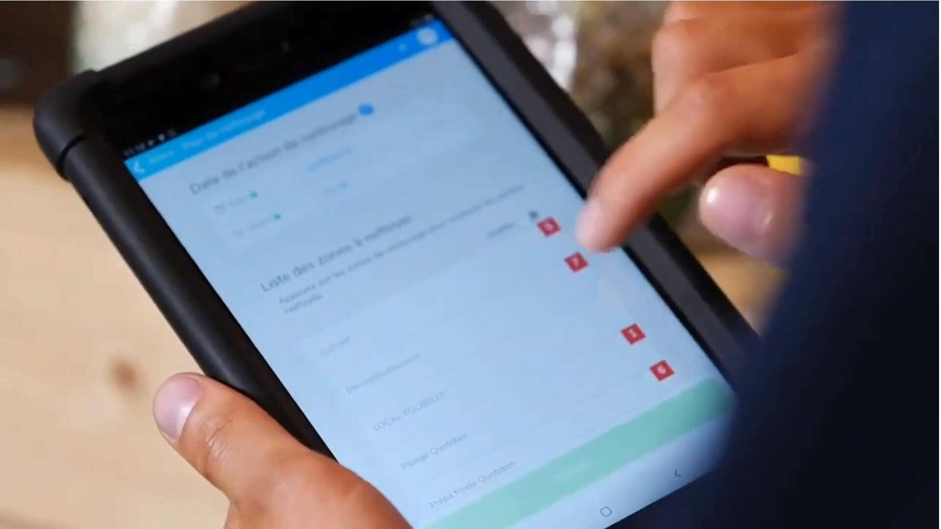 Personne utilisant une tablette tactile pour consulter ou renseigner un formulaire numérique.